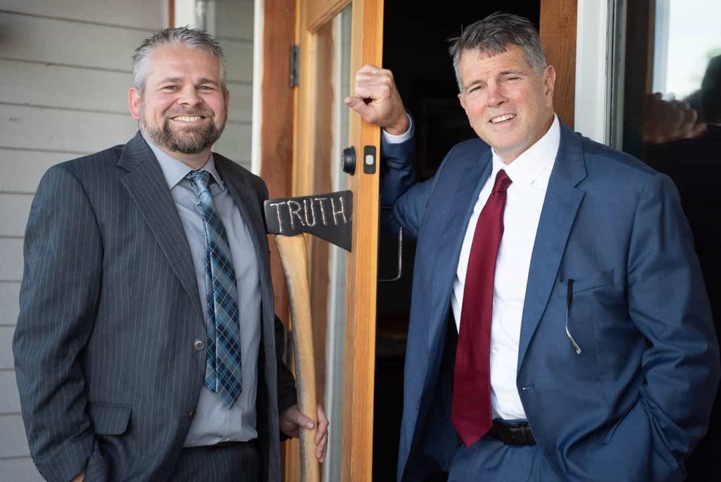 Ben Wells and Josh Trumbull are standing at their front office door.