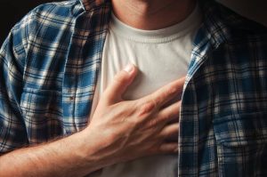 Young adult man suffering from severe chest pain.